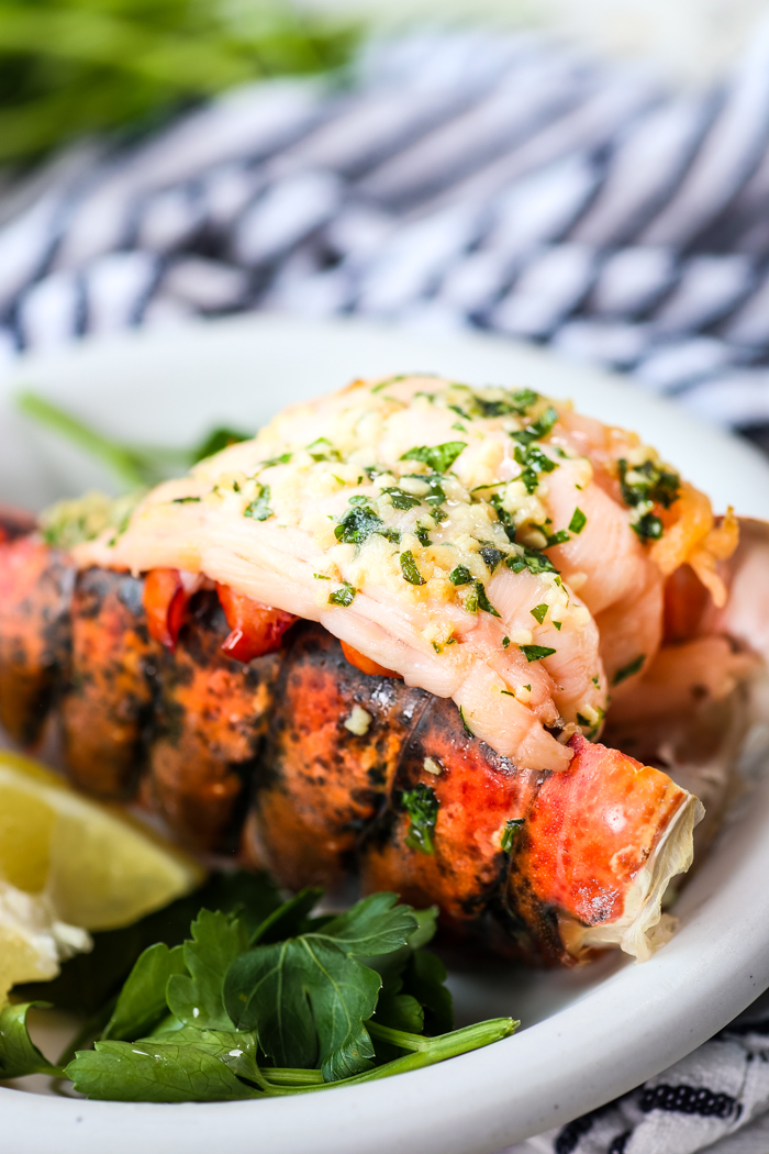 Instant Pot Cooked Lobster topped with butter and parsley and garlic