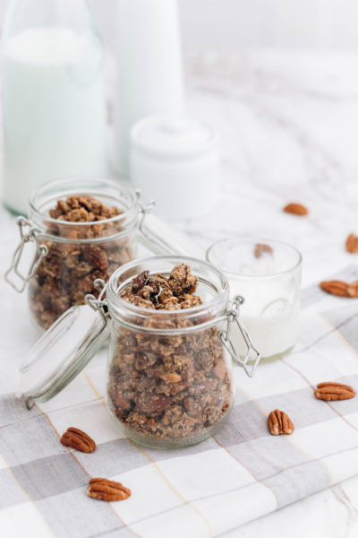 two jars of keto granola with sprinkled nuts