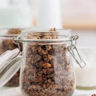 head on shot of keto granola in a glass jar one right behind it