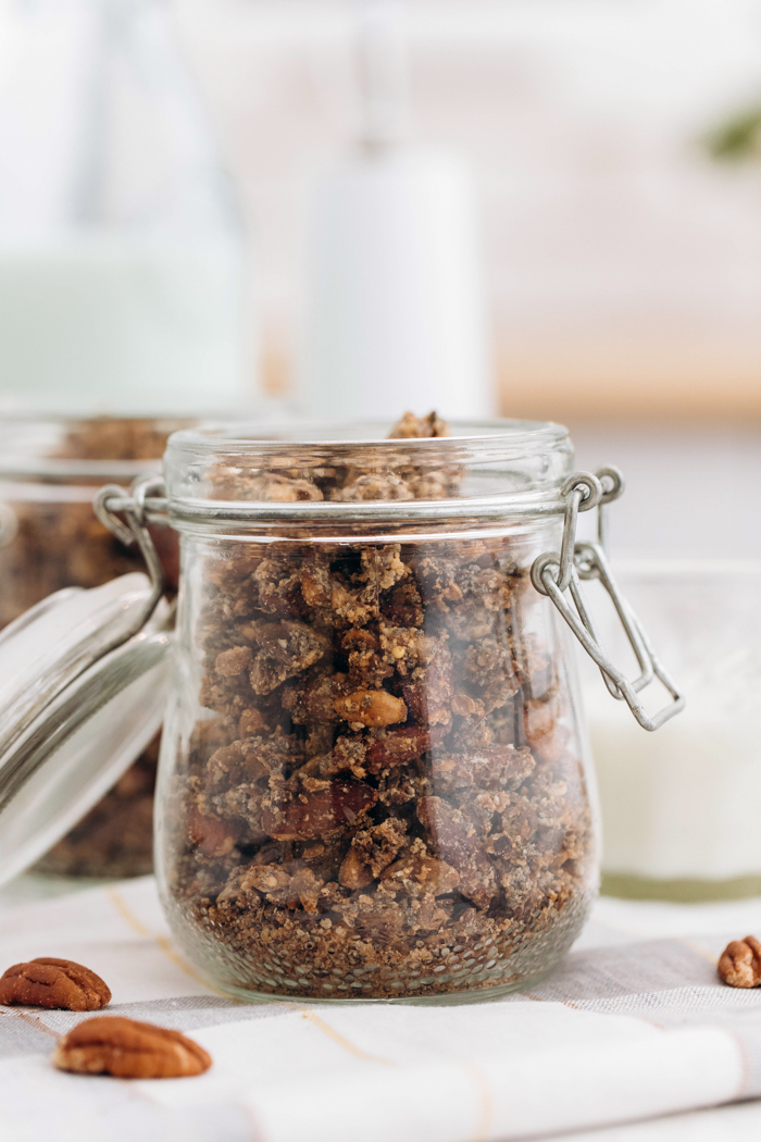head on shot of keto granola in a glass jar one right behind it