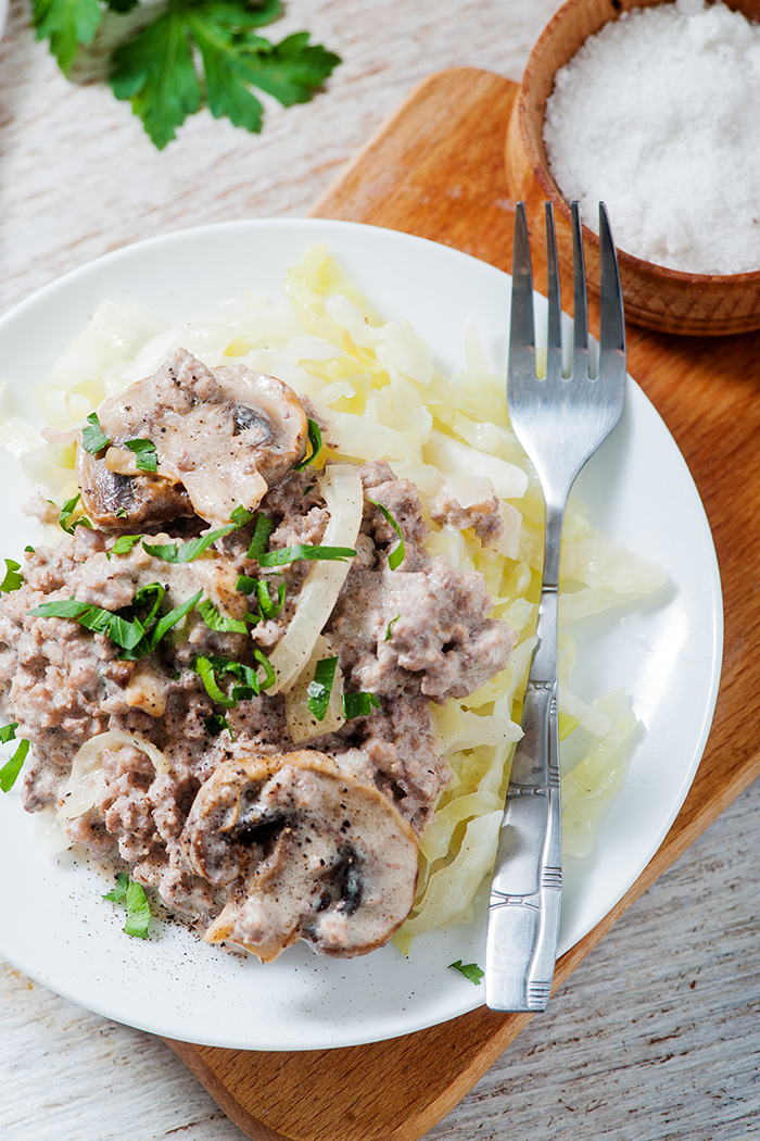 single white plate of low carb beef stroganoff with metal fork
