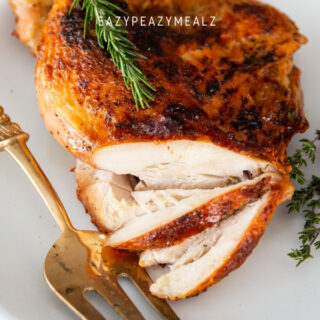 Air fryer turkey breast on a white plate, with a few slices, and a gold serving fork