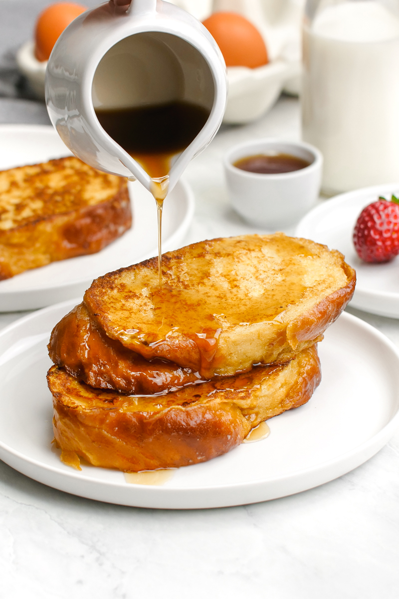 Classic french toast, a stack of two french toast slices with syrup being drizzled over the top. 