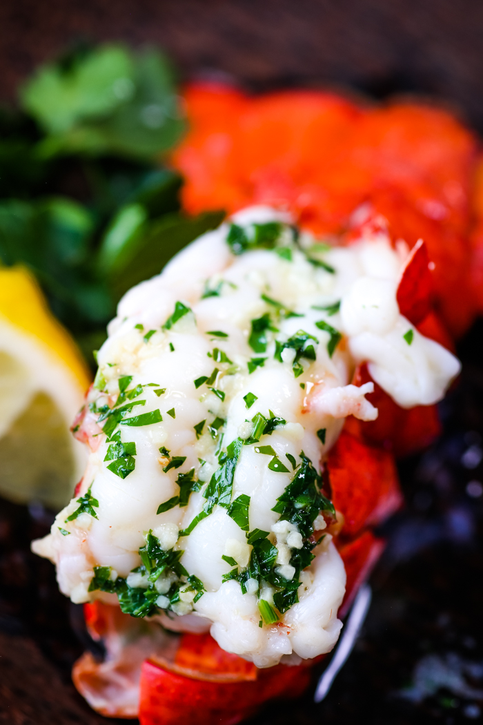 Boiled lobster tail topped with garlic butter and parsley