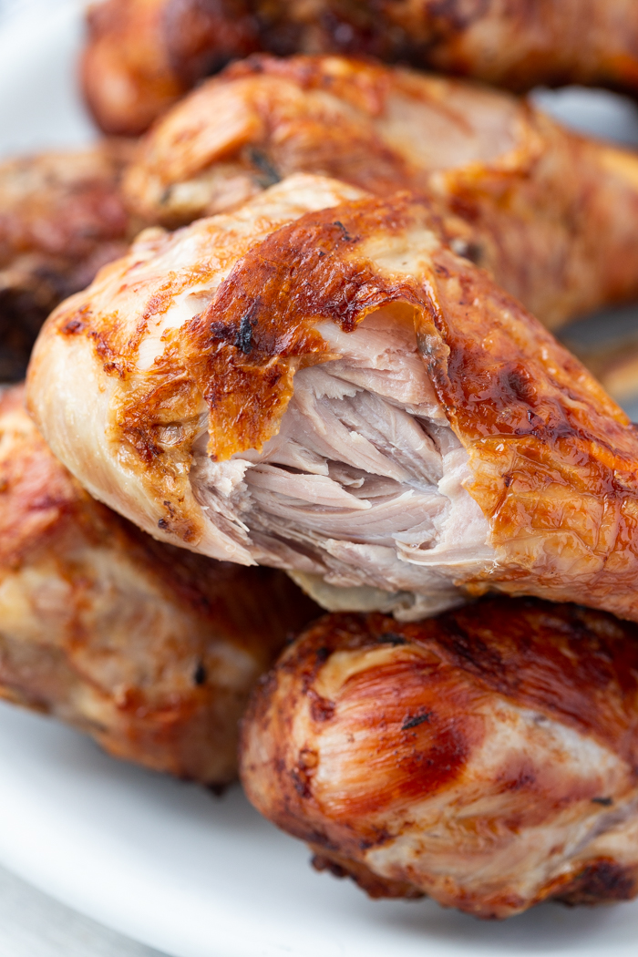 Turkey legs from the air fryer on a plate with a bite taken out of one of them