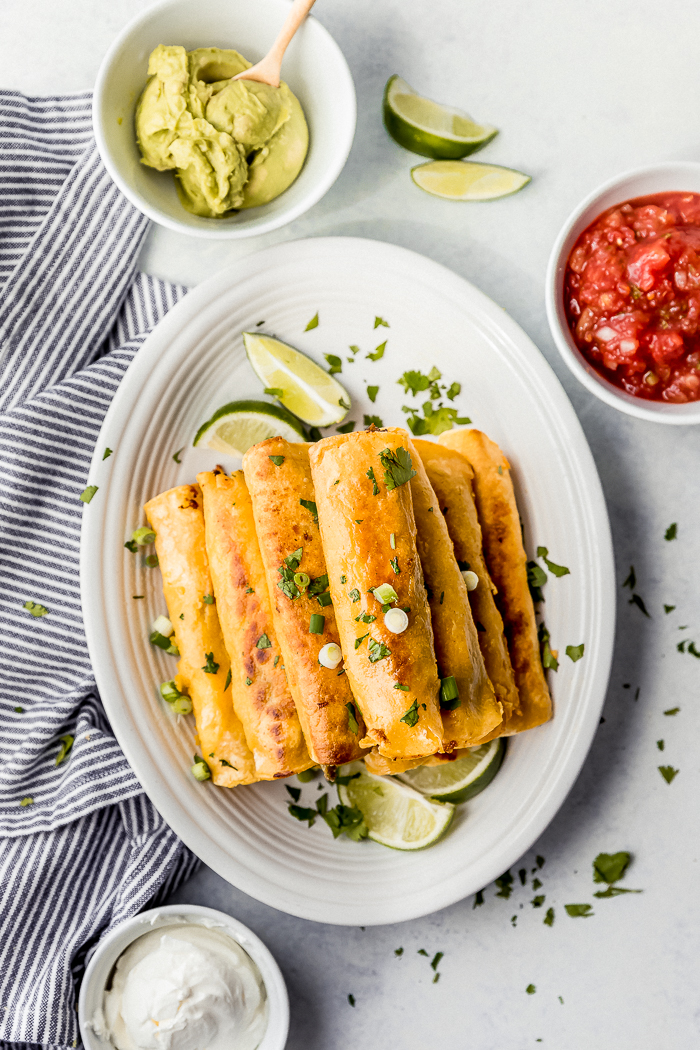 A plate of breakfast taquitos with garnish