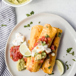 A white plate with breakfast taquitos