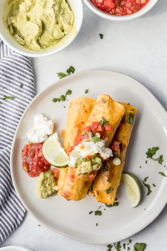 A white plate with breakfast taquitos