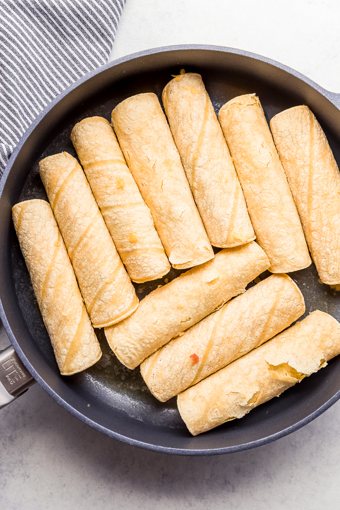 Corn tortilla taquitos in a skillet