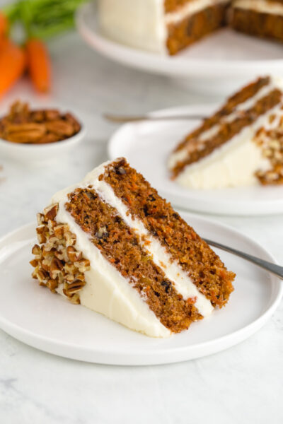 A slice of carrot cake with cream cheese frosting, two layer cake