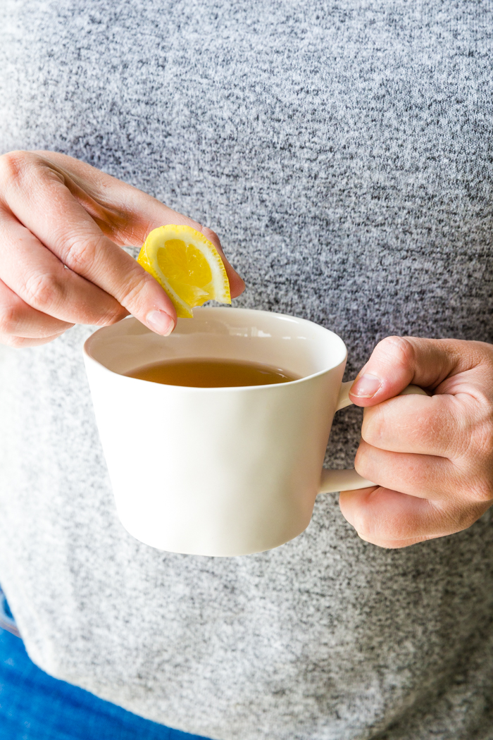 Squeezing a lemon into a cup of tea