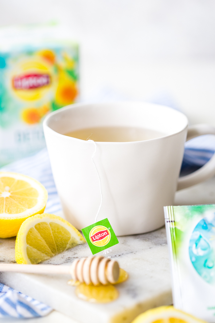 Letting your tea steep in a white mug with lemons
