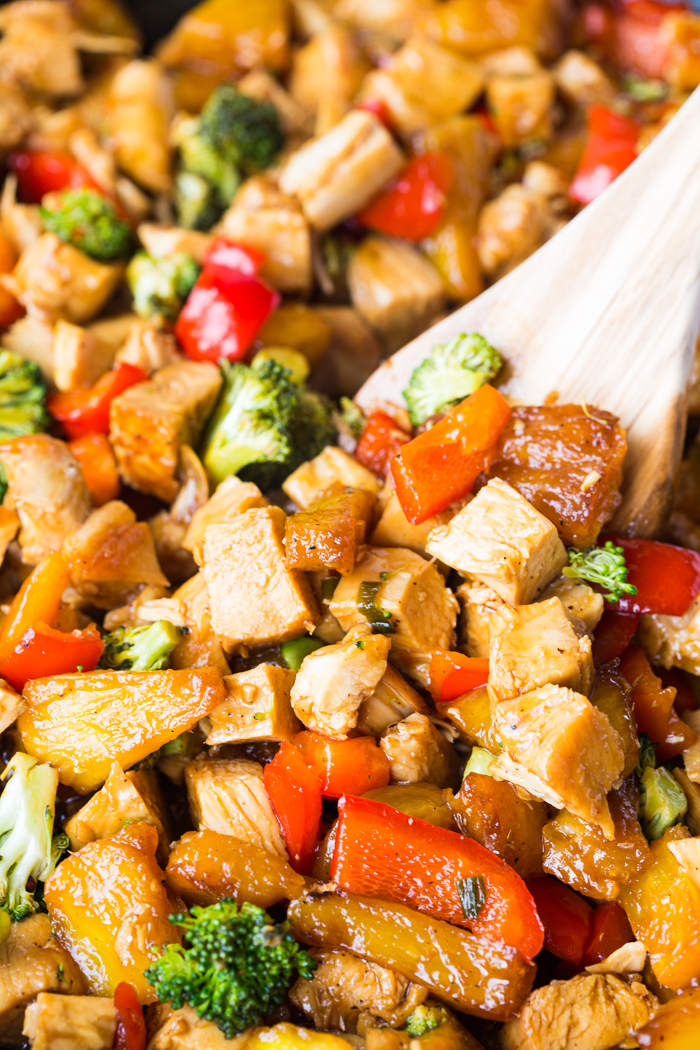 a close up of a spoonful of teriyaki chicken stir fry