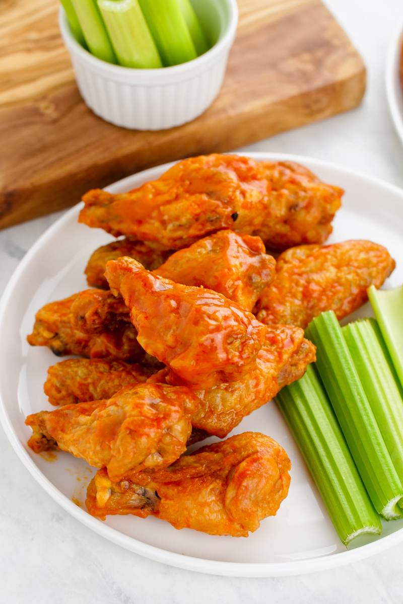 A plate of crispy buffalo wings and celery