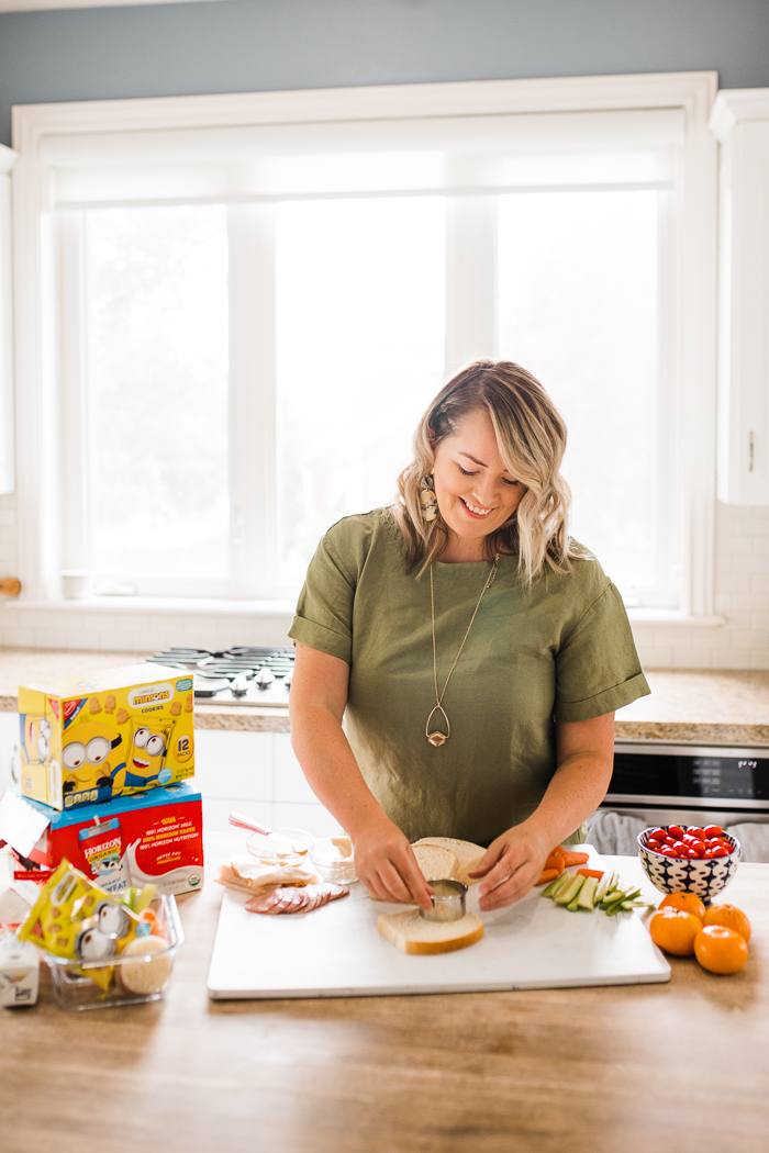 A woman in a green shirt making lunches