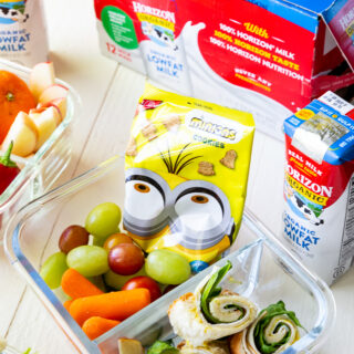 A bento style box, with sandwich sushi and other lunch fixings.