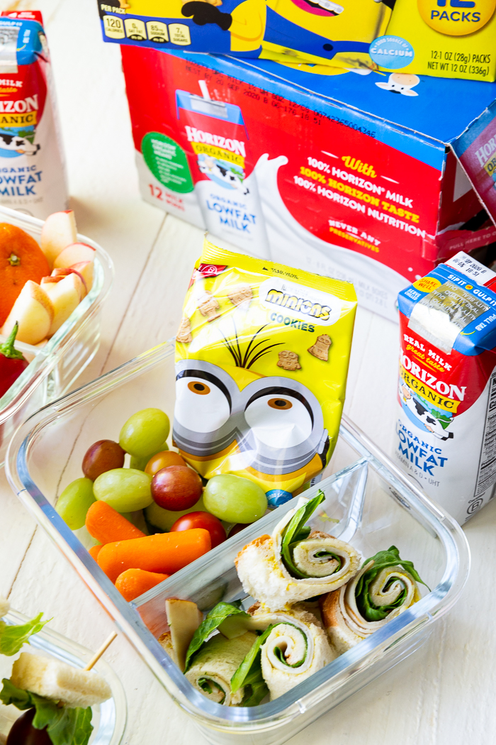 A bento style box, with sandwich sushi and other lunch fixings.