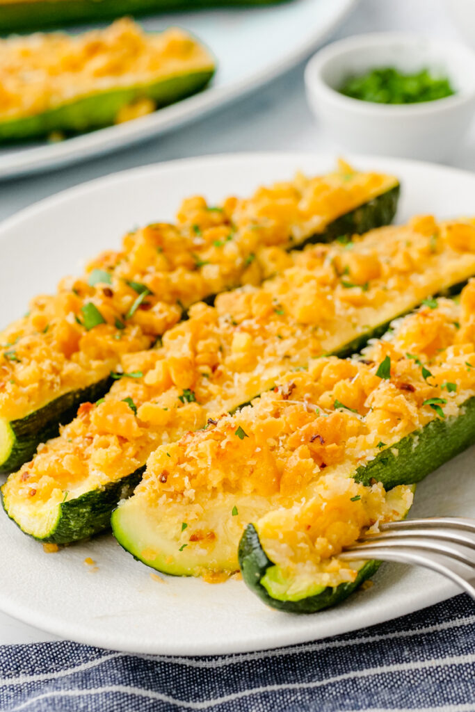 A white plate with three zucchini on it. 