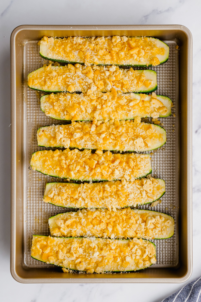 Zucchini in a baking dish, topped with a crumb mixture, and ready to be baked.