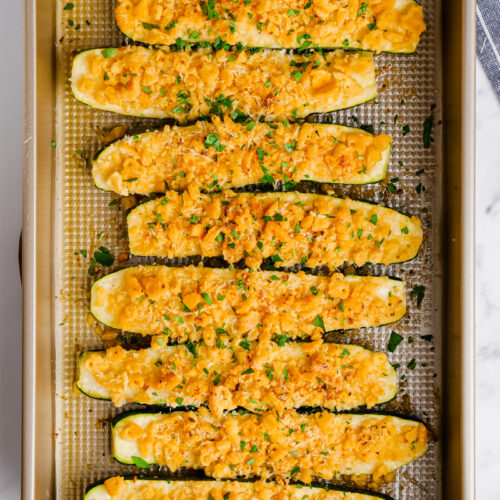 A baking dish filled with halved zucchini topped with a cracker mixture.