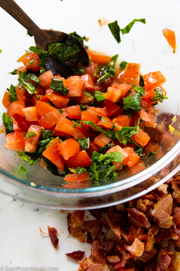 Making Bruschetta a bowl full of bruschetta with bacon on the side