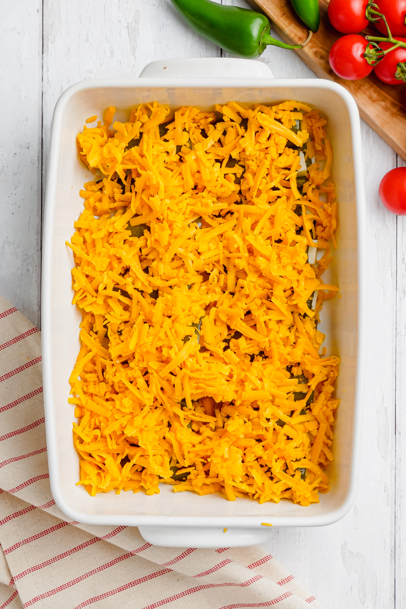 a baked chiles relenos on a white pan with a striped background