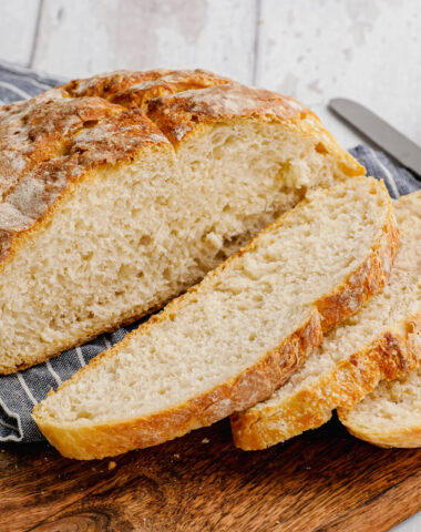 pieces of bread on a wooden cutting board with butter in the background