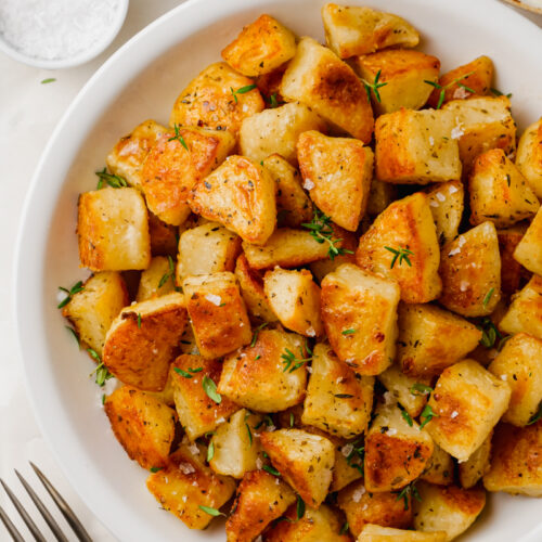 A white plate loaded with crispy potatoes