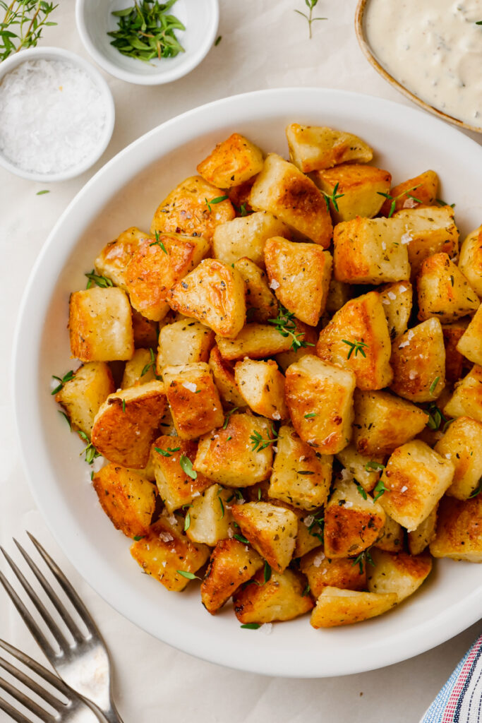 A white plate loaded with crispy potatoes