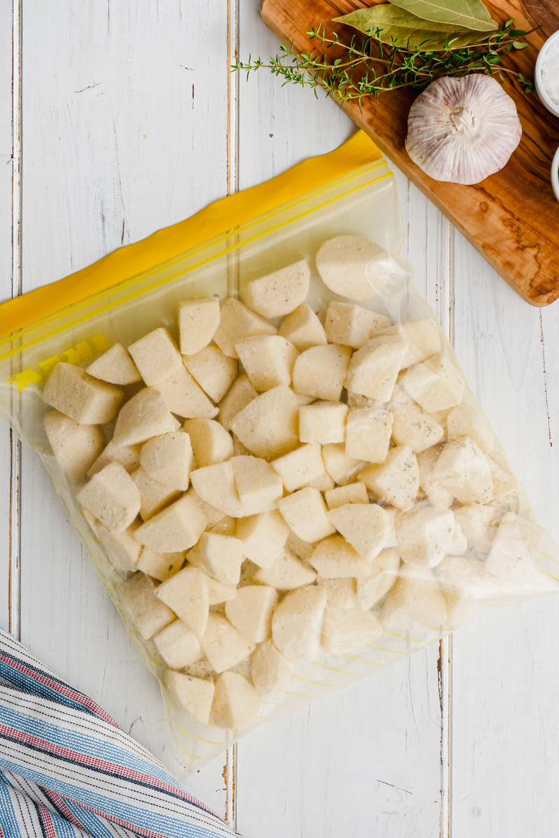 A zip top bag with peeled and cut potatoes