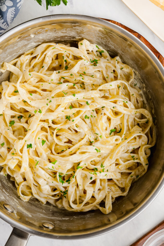 A pan filled with fettuccine alfredo, made fresh and creamy