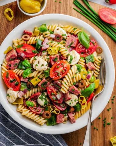 Italian pasta salad in white bowl with fork to the side