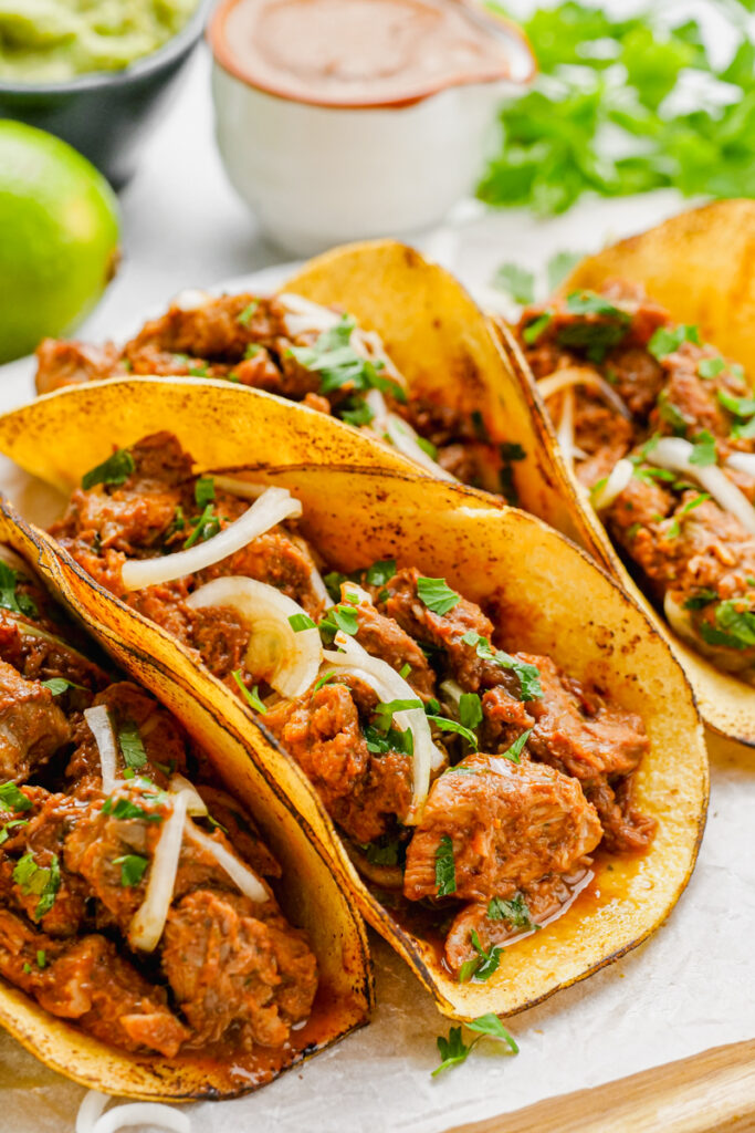 Pork mole tacos on a white plate