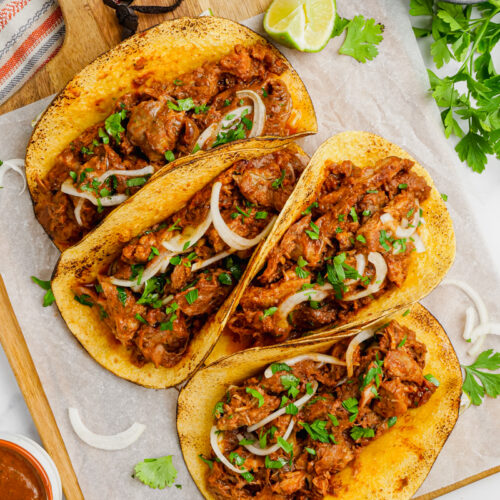 Pork mole tacos on a white plate