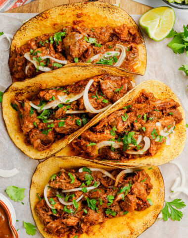 Pork mole tacos on a white plate