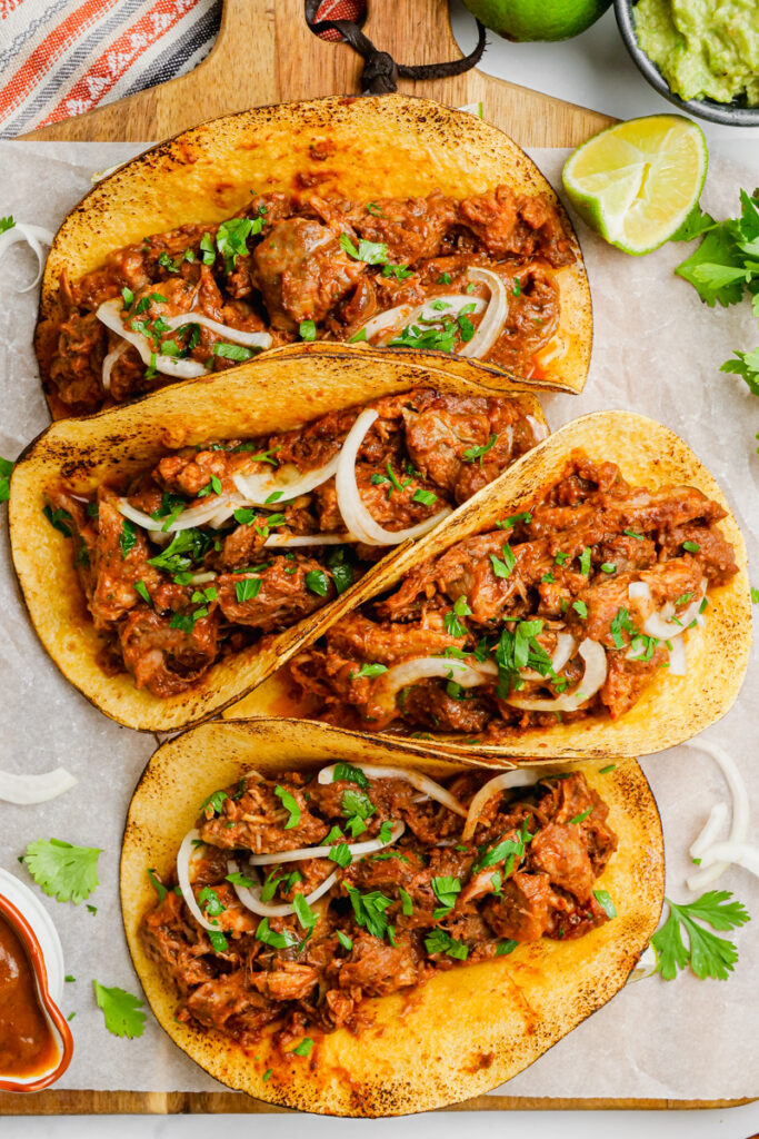 Pork mole tacos on a white plate