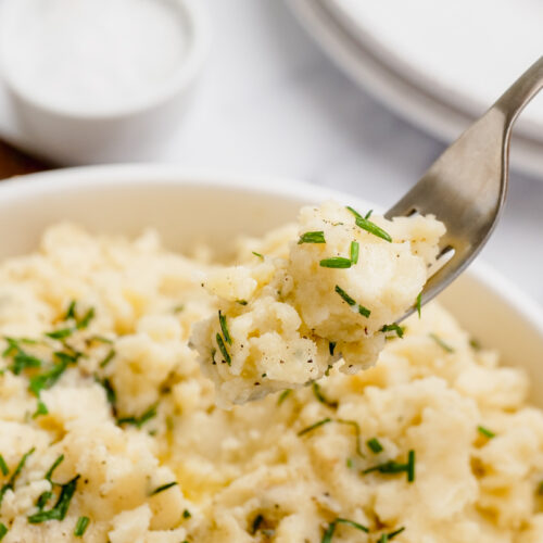 mashed potatoes in a white bowl with a fork