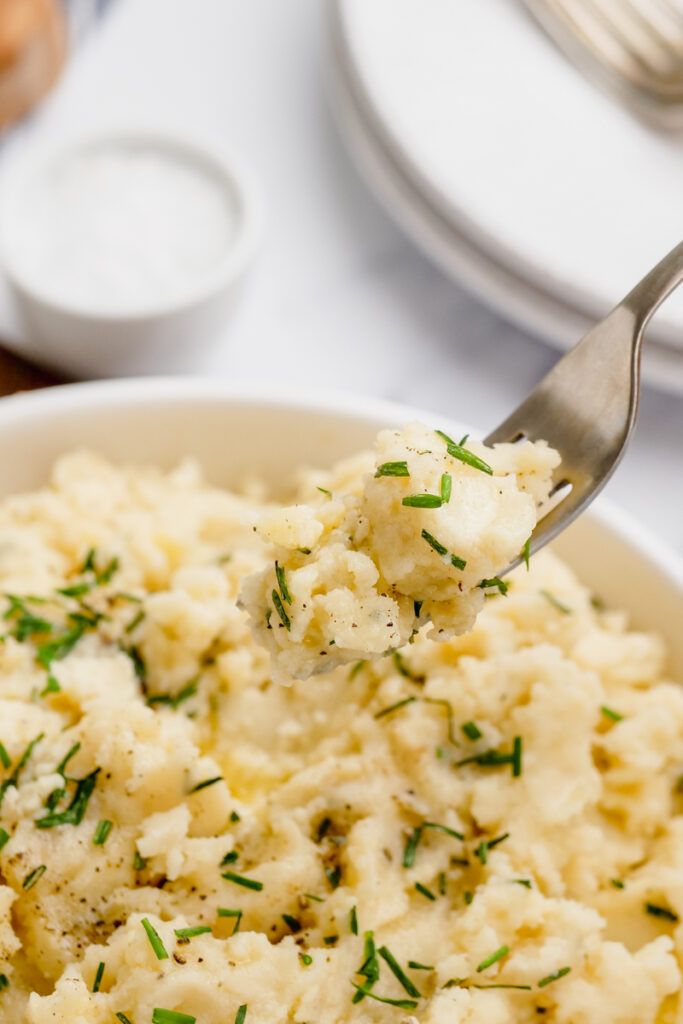 mashed potatoes in a white bowl with a fork