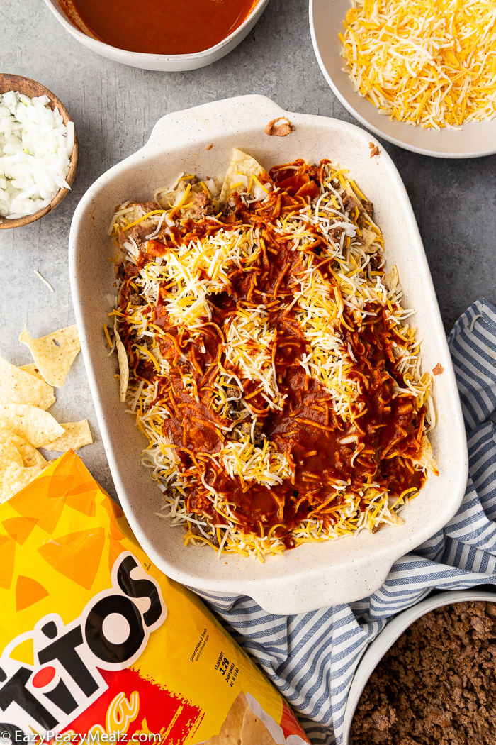 Layers of cheese and enchilada sauce on enchilada casserole.