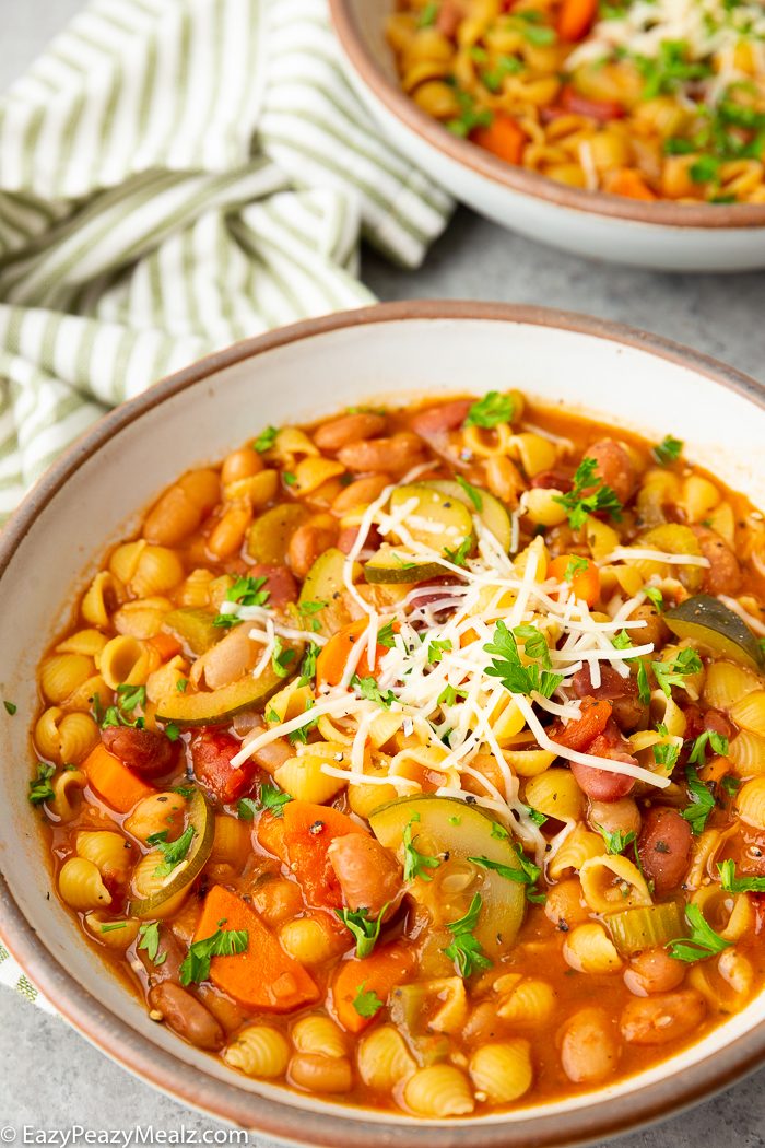 Minestrone soup garnished with parmesan cheese and parsley