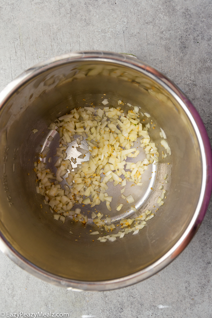 An instant pot liner with onions and garlic inside.