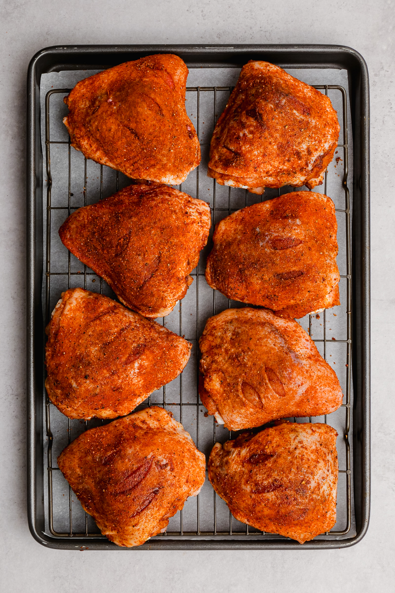 Baking sheet with chicken thighs getting ready to go into the oven to be roasted.