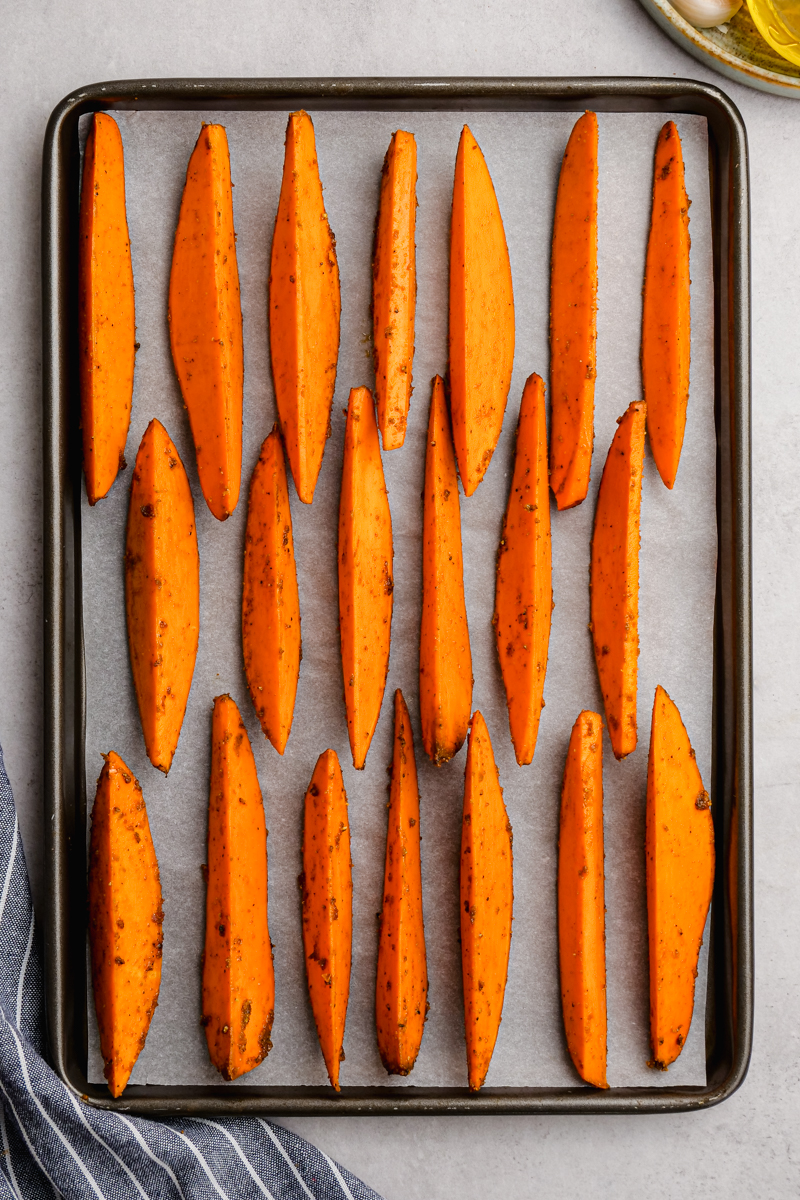 Sweet potatoes arranged skin side down on a baking sheet for being roasted