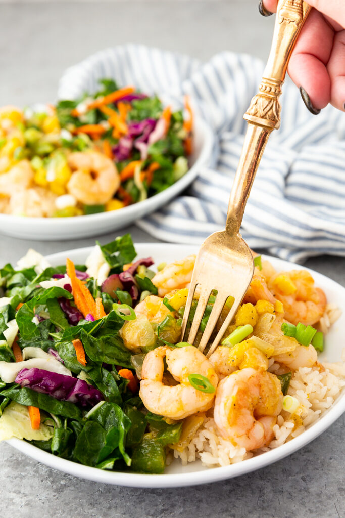 Caribbean shrimp on a plate with coconut rice and chard salad