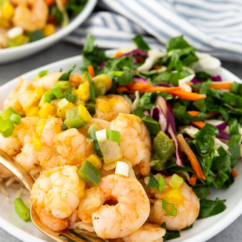 A plate with Caribbean shrimp and coconut rice and a chard salad