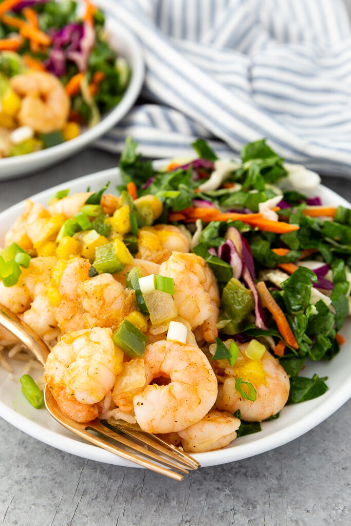 A plate with Caribbean shrimp and coconut rice and a chard salad