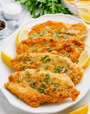 Breaded chicken cutlets on a white plate.