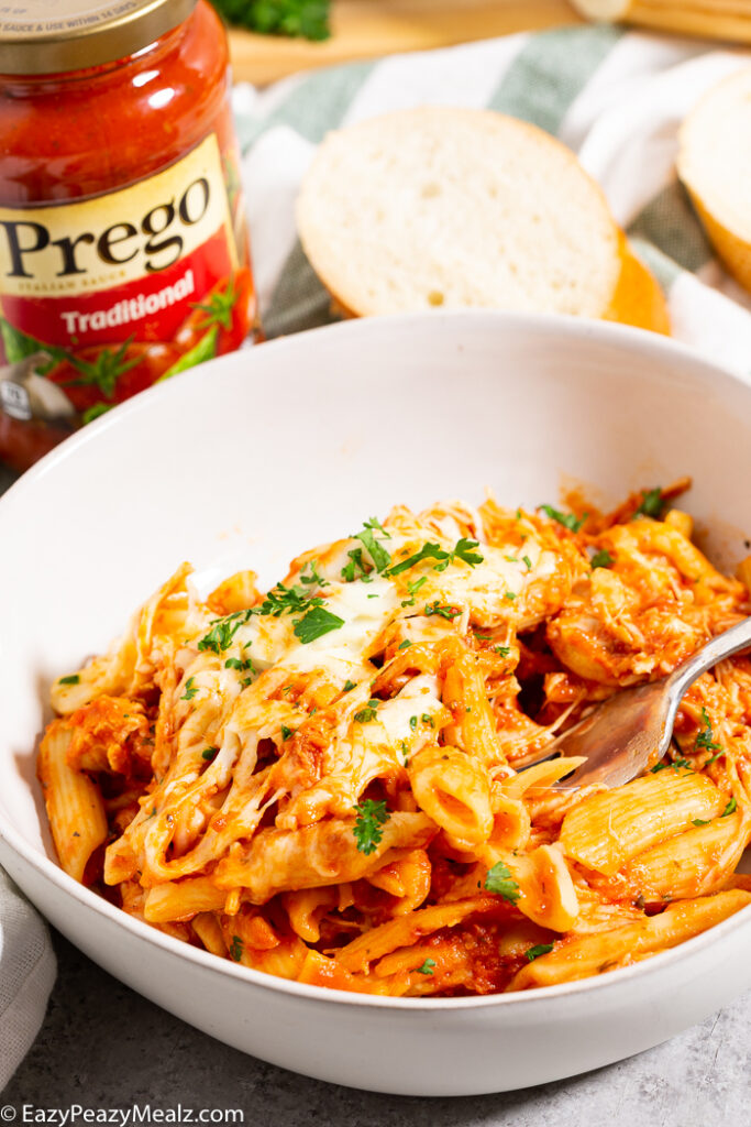 White bowl with penne and chicken parmesan made in the slow cooker