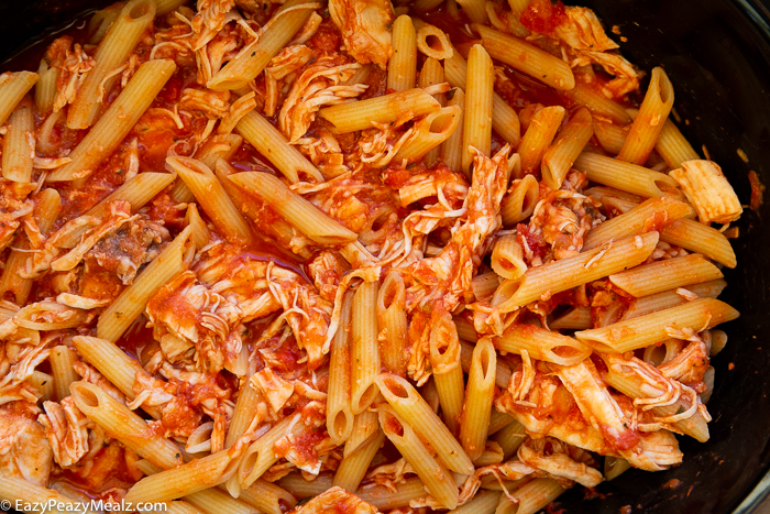 Penne with sauce, chicken and cheese in a slow cooker.