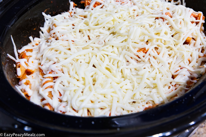 A slow cooker topped with cheese